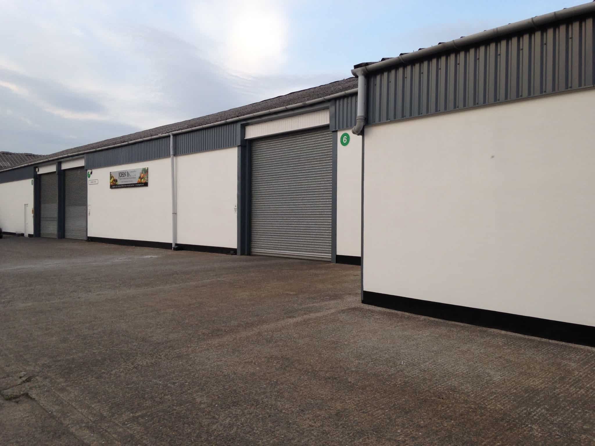 Large industrial warehouse with roll-up doors at John Patt's Wholesale UK.